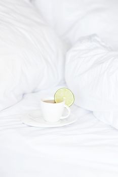 bed with a pillow and a cup of tea 