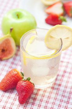 cocktail with ice,lemon, fig and strawberries on a plate