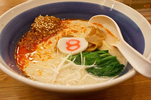 pork bone soup noodle with spicy ground pork garnished with Japanese spring onion, pak choi, kamaboko, sesame seeds and memma