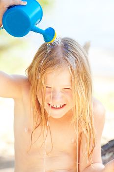 portrait of a beautiful little girl with a watering can