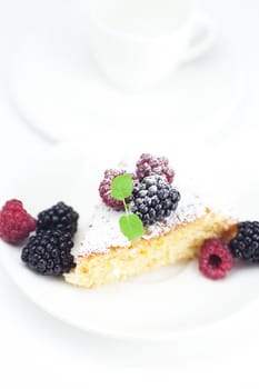 cup, cake, raspberry, blackberry and mint on a plate on a white background