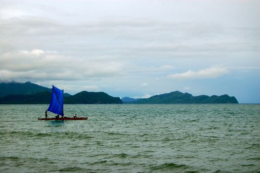 Blue sailing canoe at sea, Papua New Guinea