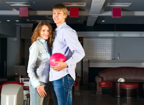 guy hugs her friendgirl, playing together in bowling