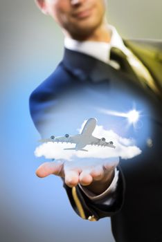 pilot in the form of extending a hand to a flying airplane with sky, clouds and sun