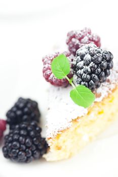 cake with icing, raspberry, blackberry and mint  on a white background