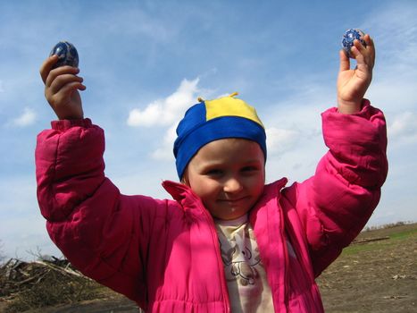 image of little girl with Easter eggs on a background of the blue sky