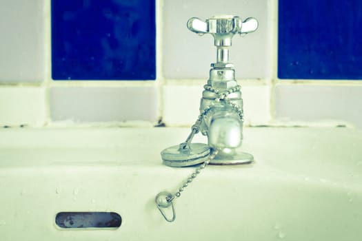 Still life image of a bathroom tap in cold tones