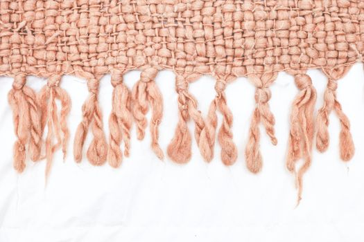 Edge of a thick wool blanket on a white duvet