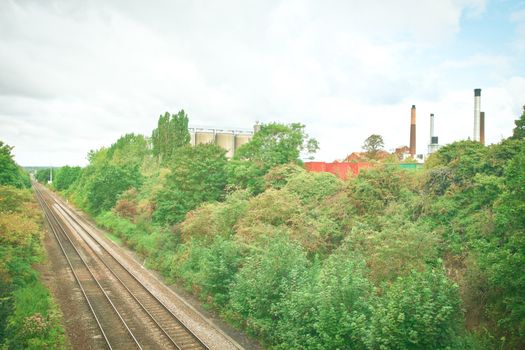 Uk landscape showing a factory site and a railway line