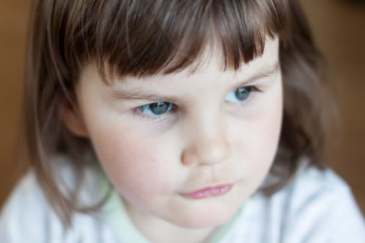 Closeup of a baby girl on the floor and looking away