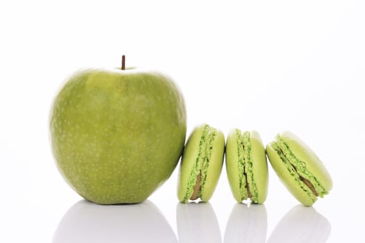 green apple with macaroons on white background
