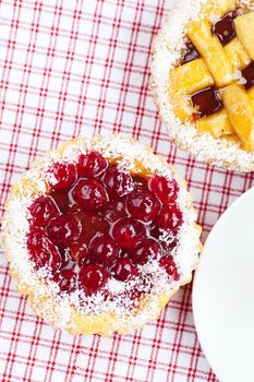 beautiful cake with berries and tea on plaid fabric