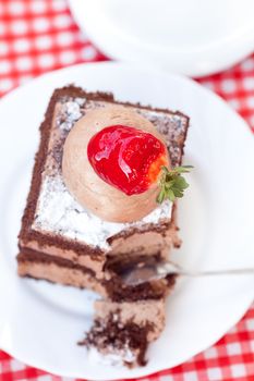 beautiful cake with strawberry and tea on plaid fabric