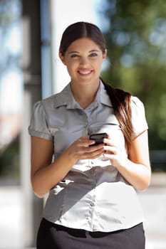 Portrait of pretty smiling businesswoman using cell phone