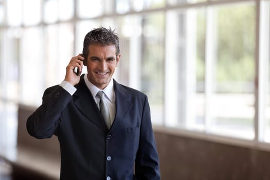 Handsome middle aged businessman talking on cell phone