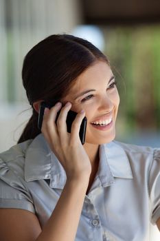 Smiling female executive talking on cell phone and looking away