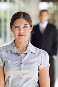 Portrait of an young attractive businesswoman with man standing in background