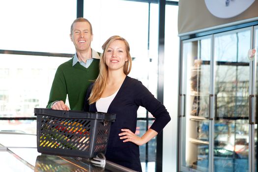 A portrait of a happy couple in a supermarket buying groceries