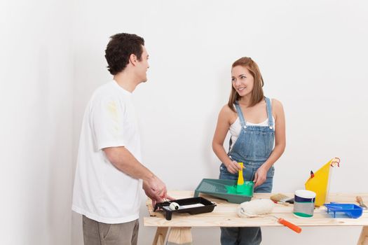 Young couple smiling at each other while mixing paint