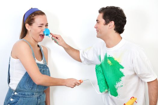 Young happy couple playing with paint against white background