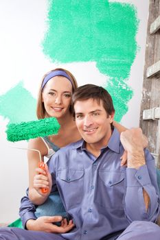 Portrait of smiling young couple with paint roller