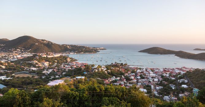 Sunset over the harbor of Charlotte Amalie in St Thomas with view over town and yachts in bay