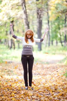 young redhead teenager throwing leaves woman in the forest  