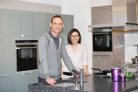 Portrait of smiling young couple standing together at dining room