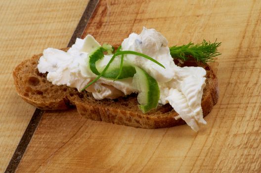 Cream Cheese Sandwich with Cucumber, Chive, Dill and Whole Wheat Bread closeup on Wooden background