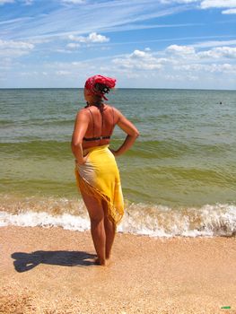The girl in bathing suit standing at the seacoast