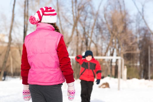 Children in Winter Park playing snowballs, actively spending time outdoors