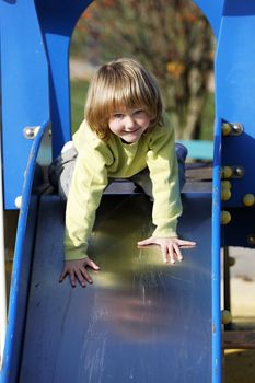 Small child playing on colorful toboggan