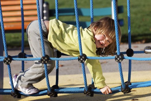 joyful child playing on colorful playground in a park