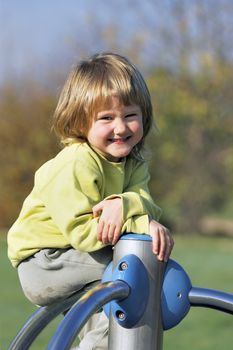 young child playing on colorful playground in a park