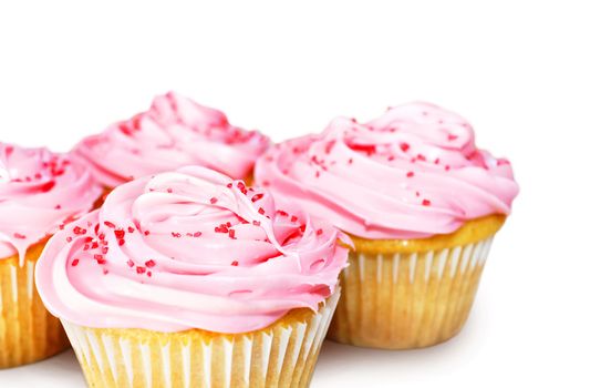 Sweet vanilla cupcakes with pink frosting over white