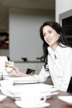 Attractive elegant woman enjoying a meal at the dinner table.