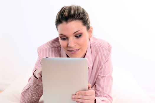 young woman lying on sofa with tablet