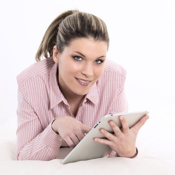 young woman lying on sofa with tablet at home