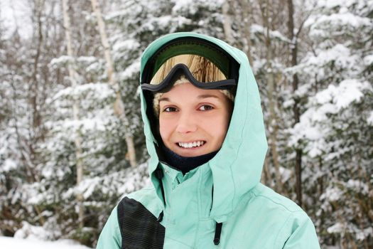 Candid portrait of a young caucasian woman wearing sky apparels enjoying the great outdoors or nature on a cold winter day.