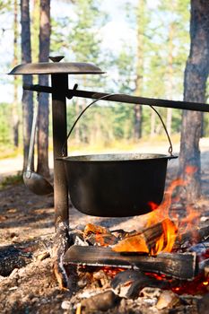 Camping kettle over burning campfire