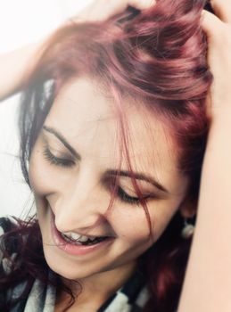 Happy young woman smiling and touching his hair