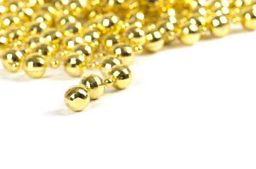 Background made of a brilliant celebratory beads of golden color over white