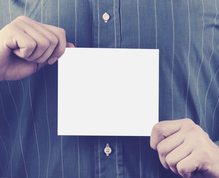 Closeup of businessman's hand holding up card