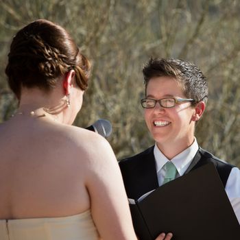 Happy lesbian lady reading vows to bride