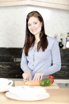 Beautiful young woman preparing the ingredients for a meal in her kitchen.