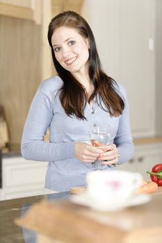 Beautiful young woman preparing the ingredients for a meal in her kitchen.