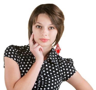 Serious European woman in polka dots with finger on cheeks