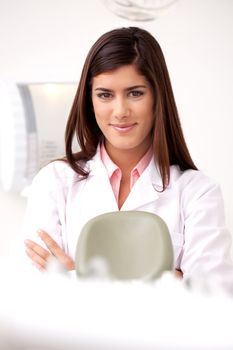 A young woman dentist smiling looking at the camera