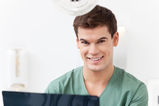 Close-up portrait of young dental assistant smiling in clinic