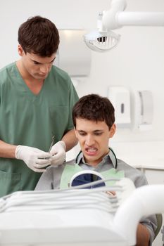 A young male patient in a dentist office looking at his teeth